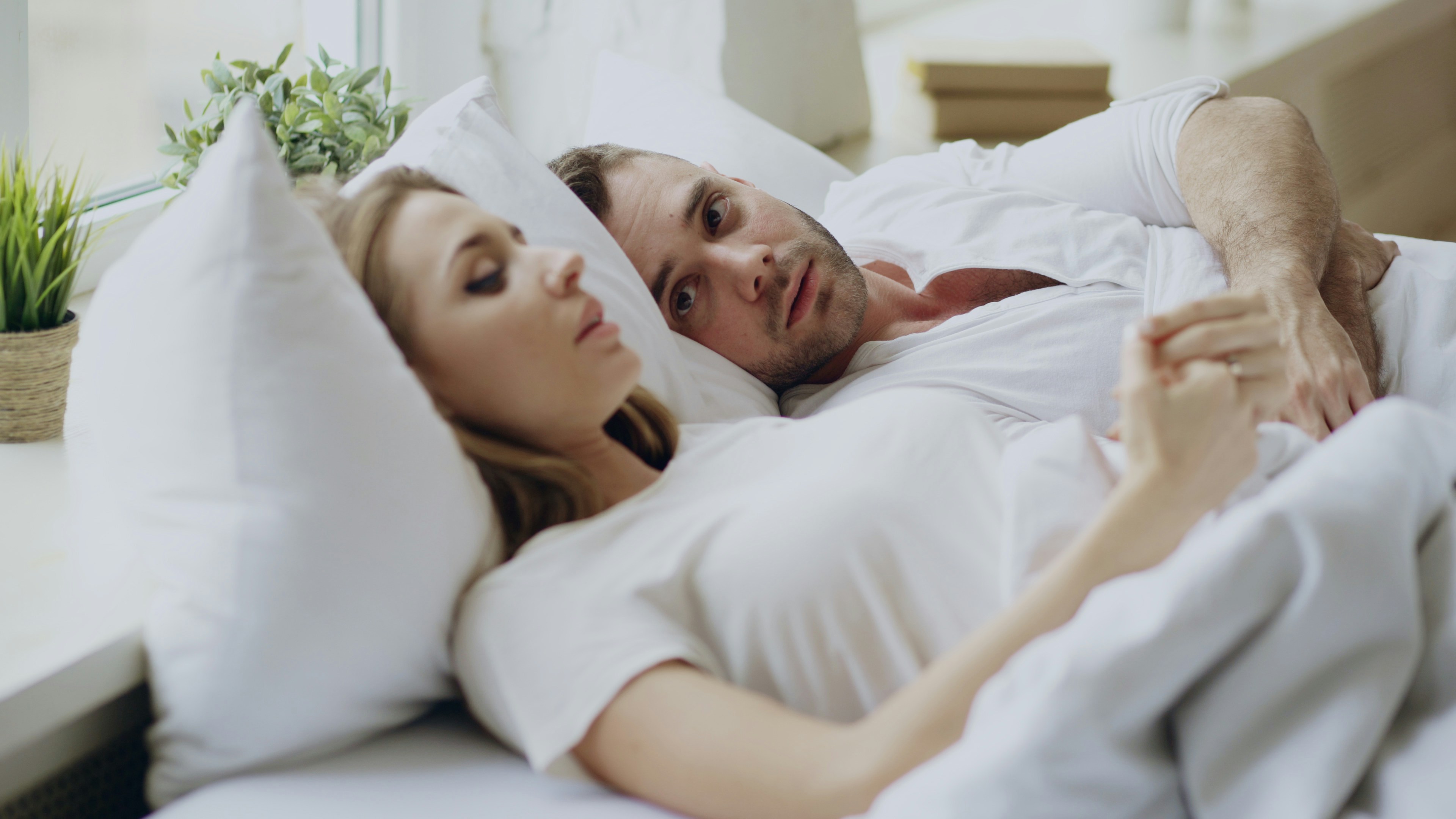 Couple sitting apart on a bed after an argument